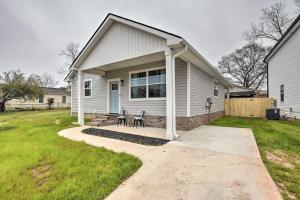 une maison blanche avec deux chaises dans une cour dans l'établissement Greenville House with Covered Patio, 2 Mi to Dtwn!, à Greenville