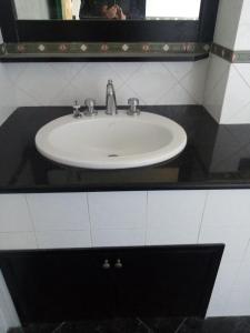 a white sink in a bathroom with a mirror at Mamena in Paestum