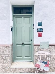 een groene deur op een wit gebouw met een bank bij Villabett Caudiel está de moda in Caudiel