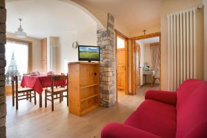 a living room with a red couch and a table at Casa Faifer mountain holiday Livigno in Livigno