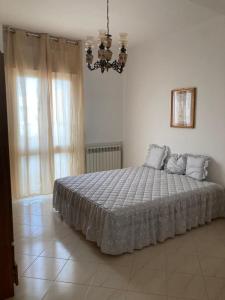 Schlafzimmer mit einem Bett und einem Kronleuchter in der Unterkunft Casa Levante in Castri di Lecce