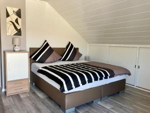a bedroom with a bed with black and white stripes at Kalverkamp Ferienwohnung in Lieser