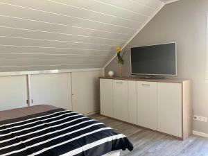 a bedroom with a bed and a flat screen tv at Kalverkamp Ferienwohnung in Lieser