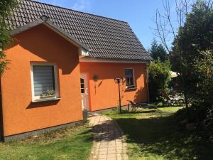 una casa naranja con ventana y patio en Ferienhaus mit Terrasse - Insel Usedom en Trassenheide
