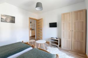 a bedroom with a bed and a table and a tv at Willa Widok in Sromowce Niżne