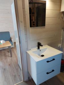 a bathroom with a white sink and a mirror at Domki na zaciszu w Rynie in Ryn