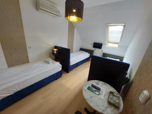 um pequeno quarto com duas camas e uma mesa em Palma Vendégház em Szeged