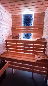 um banco de madeira numa sauna com uma janela em Willa Ramzówka - Domek w Beskidzie Sądeckim em Nowy Sącz