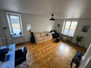 Apartment in Stockholm, 48m2 in Mariatorget Södermalm في ستوكهولم: غرفة معيشة مع أريكة ونوافذ