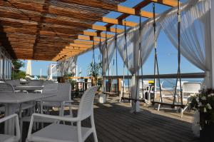 a restaurant with white chairs and tables on a deck at Apartament Gdańsk Sun and Sea in Gdańsk