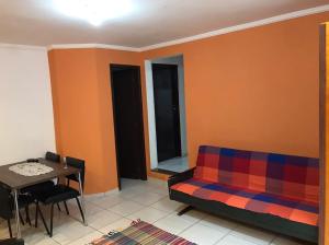 - un salon avec un canapé et une table dans l'établissement Apê Aconchego, à Águas de São Pedro