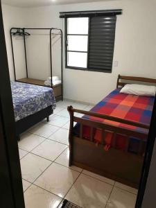 1 dormitorio con 2 camas y espejo. en Apê Aconchego en Águas de São Pedro