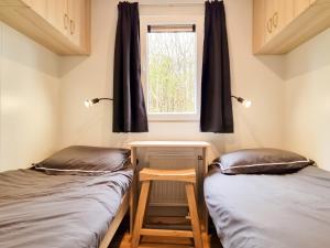 two beds in a room with a window at Luxe chalet AK09 Aagtekerke in Aagtekerke