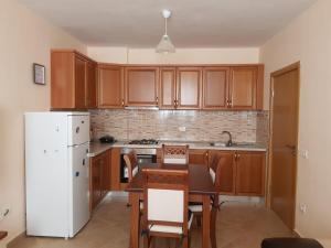 a kitchen with a table and a white refrigerator at Seaside Nest Shengjin in Shëngjin