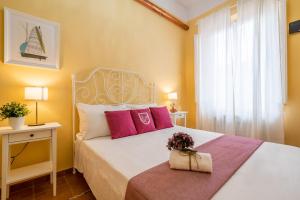 ピサにあるLH-Casa Doraのベッドルーム(ピンクの枕が付いた白いベッド付)