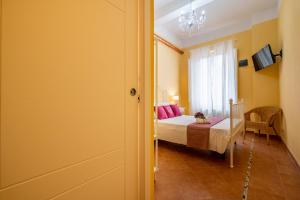 a bedroom with a bed with pink pillows and a window at LH-Casa Dora in Pisa