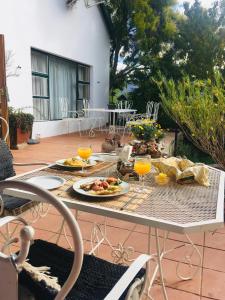 a table with a plate of food and two glasses of orange juice at Finchley Farm Cottages in Willowmore