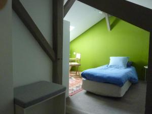 a bedroom with a bed and a green wall at Etage privatif in Tarbes