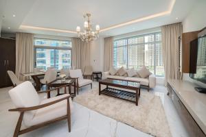 Elle comprend un salon doté d'un mobilier blanc et de grandes fenêtres. dans l'établissement Luton Vacation Homes - Park Island, marina view-Dubai Marina-60AB5, à Dubaï