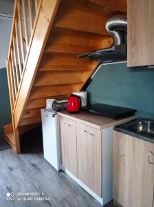 una cocina con fregadero y una escalera en Domek przy stajni, en Gajrowskie