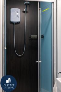 La salle de bains est pourvue d'une douche avec un pommeau de douche. dans l'établissement Flatzy - Charming Garden Annexe in Aigburth with Kitchenette, à Liverpool
