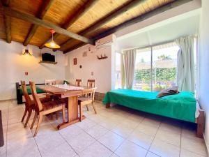 1 dormitorio con mesa, 1 cama y comedor en Cabañas El Naranjo, en San Rafael