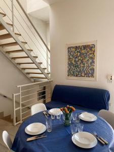 a dining room table with a blue table cloth and a staircase at A 100metri dal mare difronte alla torre saracena. in Campomarino