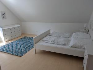 a bedroom with a bed and a dresser and a rug at Haus Eisfenn in Blankenheim