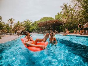 a group of people in a pool at a resort at Viajero Tayrona Hostel & Ecohabs in Buritaca