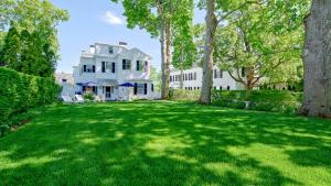 une grande cour devant une maison blanche dans l'établissement Captain Morse House - Luxury, Waterfront, Town, & Beaches - 5 stars, à Edgartown