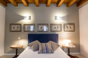 een slaapkamer met een bed met drie foto's aan de muur bij Palazzo Fracastoro in Verona