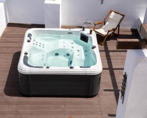 a jacuzzi tub in a room with a chair at Sunny Bay in Agia Marina +71 photos