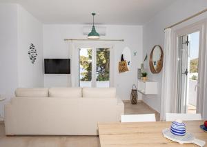 a white living room with a white couch at Sunny Bay in Agia Marina