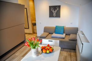 ein Wohnzimmer mit einem Sofa und einem Tisch mit einer Obstschale in der Unterkunft Les Studios du Pêcheur - Hypercentre - Clim - City Trip in Ajaccio
