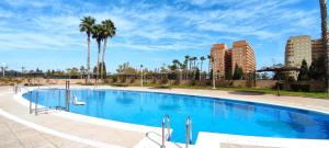 ein großer Swimmingpool mit Palmen und Gebäuden in der Unterkunft ACV - Costa Caribe II-2ª Linea Planta 4 Sur in Oropesa del Mar