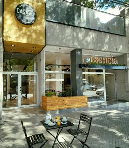Casa Be Suites في روزاريو: مقهى وكراسي وطاولة أمام المبنى