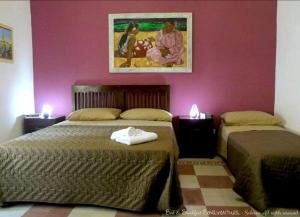 a bedroom with two beds and a painting on the wall at Bed & Breakfast Bonaventura in Salerno
