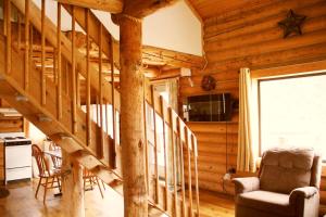 ein Wohnzimmer mit einer Treppe in einem Blockhaus in der Unterkunft High country Guest Ranch in Hill City