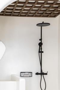 una lámpara negra en una pared blanca con techo en Imera Vista Suites en Imerovigli