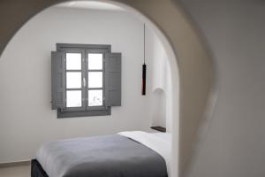 1 dormitorio con cama y ventana en Imera Vista Suites en Imerovigli