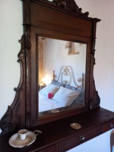 a mirror on a dresser with a bed in it at LA BOTTEGA DEL CALZOLAIO in Castiglion Fibocchi