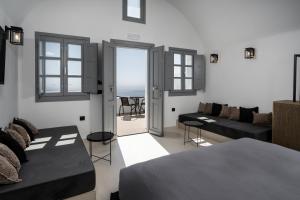 1 dormitorio con cama, sofá y mesa en Imera Vista Suites en Imerovigli