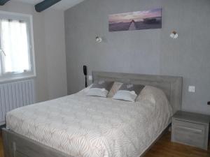 a bedroom with a bed with a white comforter at Logis Hotel et restaurant Auberge Le Ratelier in Carnac