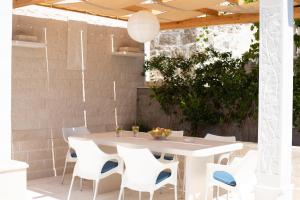 an outdoor patio with a white table and chairs at BUKY HOUSE in Sumartin