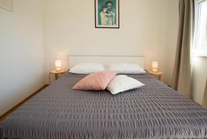 a bedroom with a bed with two pillows on it at BUKY HOUSE in Sumartin