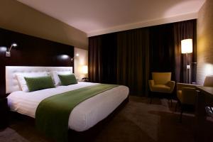 ウーデンにあるホテル アローズの大きなベッドとデスクが備わるホテルルームです。