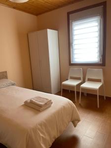 a bedroom with a bed and two chairs and a window at Apartment Lecer 4 in Porta