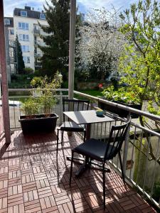 een patio met een tafel en stoelen op een balkon bij Zentrale Ferienwohnung mit Balkon in Aachen in Aken