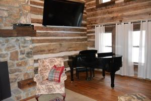 a living room with a piano and a stone wall at Altamont Lodge in Newland