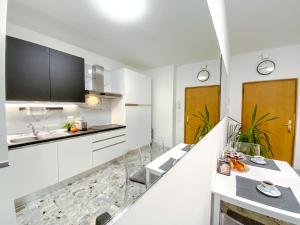 a kitchen with white cabinets and a counter top at B&B Stella in Rovereto